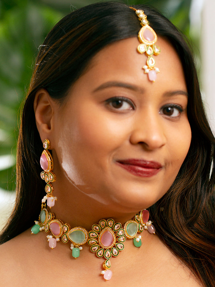 Close-up of a woman wearing an ornate traditional Pink & Green Choker jewellery set and earrings and maangtikka with Kundan, Monalisa Stone, American Diamonds, Beads and Reverse American Diamonds and tumble stones. A graceful woman wearing a trending Colored Stone necklace for a 2026 wedding celebration. Elegant wedding jewelry look featuring a premium artificial Colored Stone necklace.