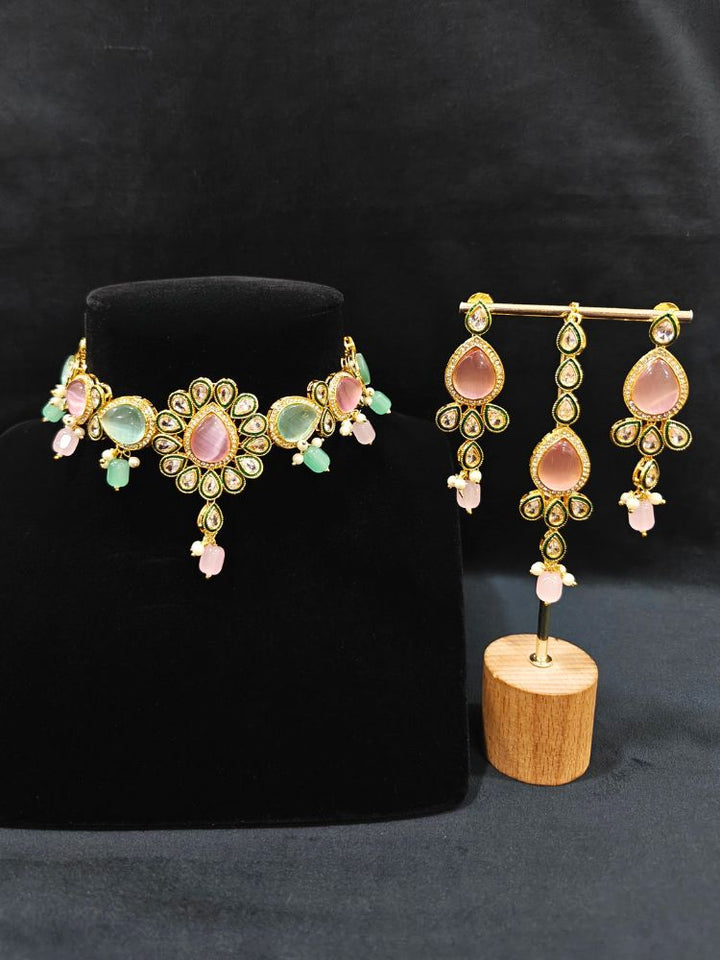 Close-up of an ornate traditional Pink & Green Choker jewellery set and earrings and maangtikka with Kundan, Monalisa Stone, American Diamonds, Beads and Reverse American Diamonds and tumble stones. A graceful woman wearing a trending Colored Stone necklace for a 2026 wedding celebration. Elegant wedding jewelry look featuring a premium artificial Colored Stone necklace.