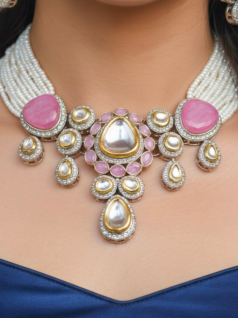 Close-up of a woman wearing an ornate traditional Pink Collar Kundan jewellery set and earrings with American diamonds, Monalisa stone, Pearls, Kundan and Colored Stones. Festive Diwali outfit paired with a premium Kundan jewelry piece. Woman wearing trending Kundan artificial jewelry for wedding season in India.