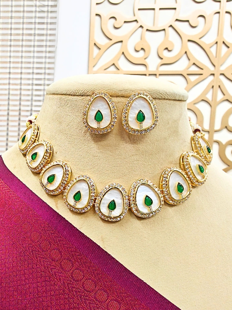 The Pragati Green Necklace Set features white necklace and matching earrings with white oval stones, surrounded by american diamonds, and teardrop-shaped multicolored gems in the center of each oval—perfect Wedding Ceremony Jewelry, shown on a mannequin bust.