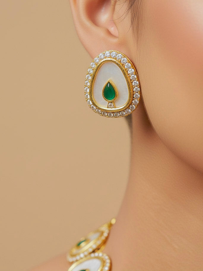 Close-up of a woman wearing an ornate traditional (Gold Polish) Green Collar Jewellery Set and Earrings with Green Colored Stone and American Diamonds. Festive celebration look enhanced with sparkling artificial American Diamond jewelry. Saree look completed with elegant artificial American Diamond jewelry for festive occasions.