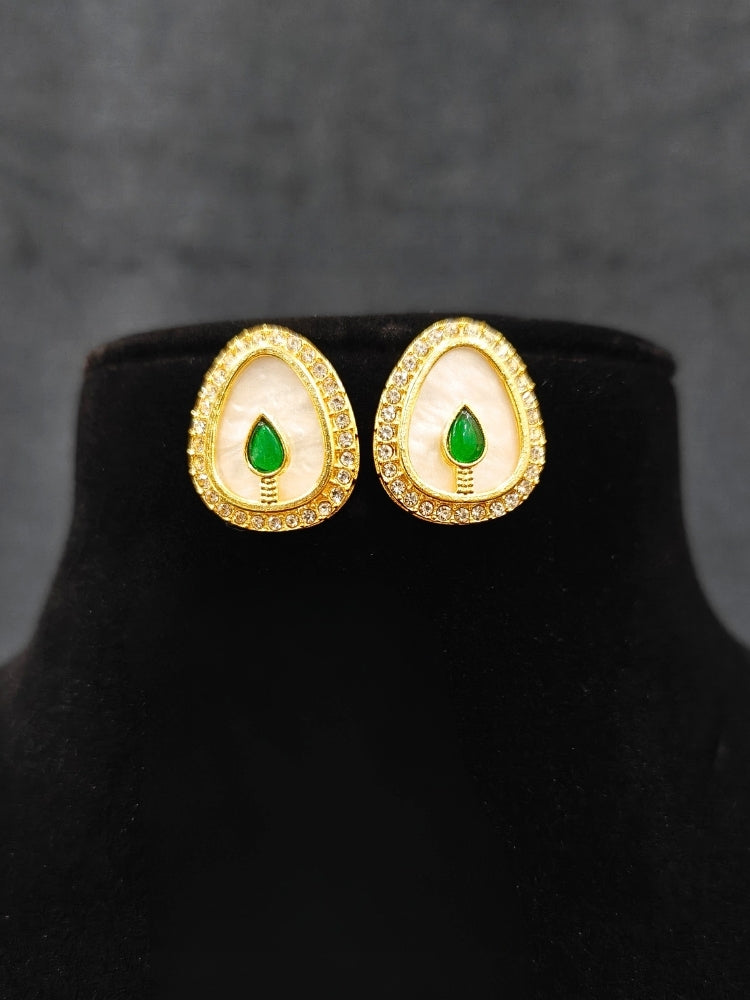 Close-up of an ornate traditional (Gold Polish) Green Collar Jewellery Set and Earrings with Green Colored Stone and American Diamonds. Festive celebration look enhanced with sparkling artificial American Diamond jewelry. Saree look completed with elegant artificial American Diamond jewelry for festive occasions.