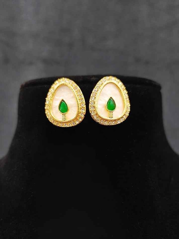 Close-up of an ornate traditional (Gold Polish) Green Collar Jewellery Set and Earrings with Green Colored Stone and American Diamonds. Festive celebration look enhanced with sparkling artificial American Diamond jewelry. Saree look completed with elegant artificial American Diamond jewelry for festive occasions.