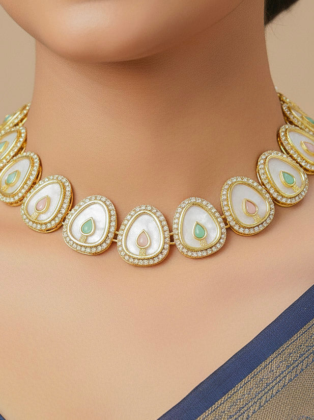 Close-up of a woman wearing an ornate traditional (Gold Polish) Mint Pink & Green Collar Jewellery Set and Earrings with Mint Pink & Green Colored Stone and American Diamonds. Festive celebration look enhanced with sparkling artificial American Diamond jewelry. Saree look completed with elegant artificial American Diamond jewelry for festive occasions.