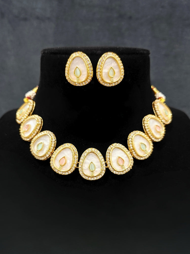 Close-up of a woman wearing an ornate traditional (Gold Polish) Mint Pink & Green Collar Jewellery Set and Earrings with Mint Pink & Green Colored Stone and American Diamonds. Festive celebration look enhanced with sparkling artificial American Diamond jewelry. Saree look completed with elegant artificial American Diamond jewelry for festive occasions.