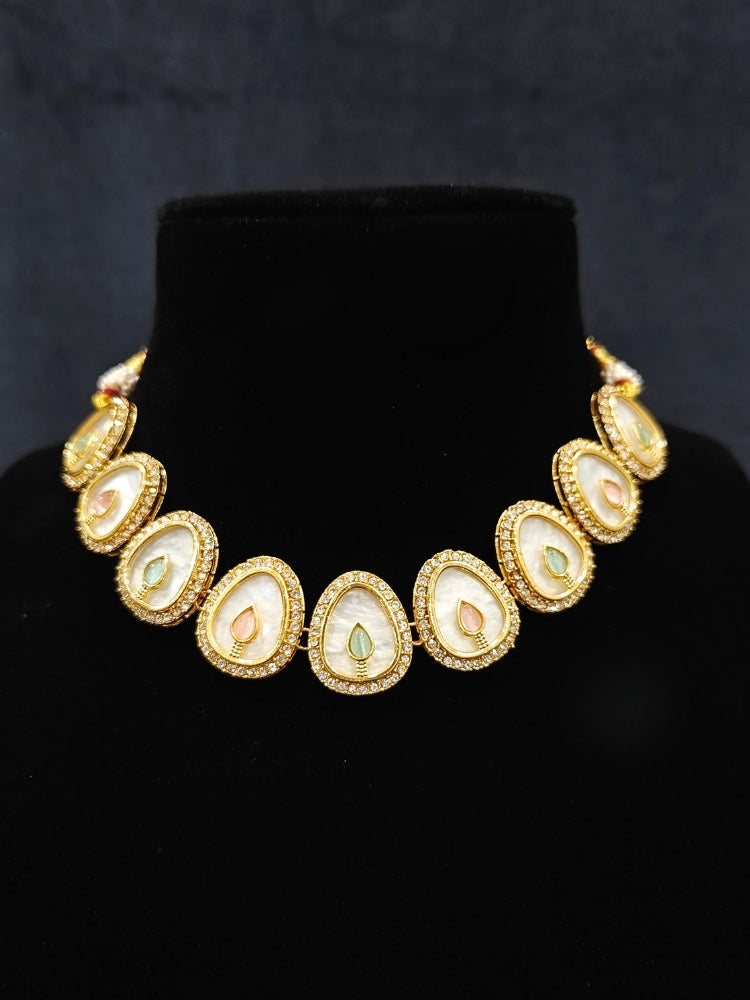 Close-up of a woman wearing an ornate traditional (Gold Polish) Mint Pink & Green Collar Jewellery Set and Earrings with Mint Pink & Green Colored Stone and American Diamonds. Festive celebration look enhanced with sparkling artificial American Diamond jewelry. Saree look completed with elegant artificial American Diamond jewelry for festive occasions.