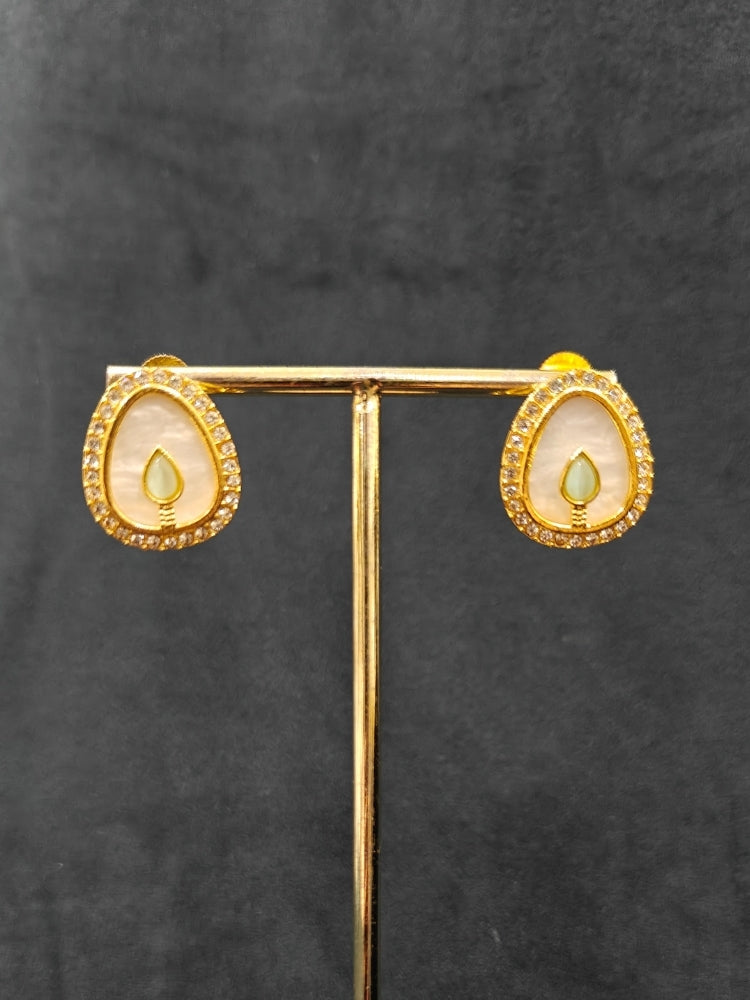 Close-up of a woman wearing an ornate traditional (Gold Polish) Mint Pink & Green Collar Jewellery Set and Earrings with Mint Pink & Green Colored Stone and American Diamonds. Festive celebration look enhanced with sparkling artificial American Diamond jewelry. Saree look completed with elegant artificial American Diamond jewelry for festive occasions.