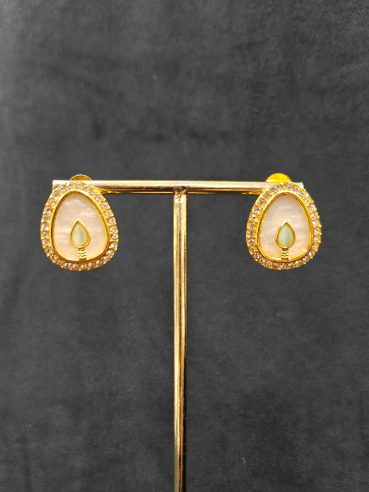 Close-up of a woman wearing an ornate traditional (Gold Polish) Mint Pink & Green Collar Jewellery Set and Earrings with Mint Pink & Green Colored Stone and American Diamonds. Festive celebration look enhanced with sparkling artificial American Diamond jewelry. Saree look completed with elegant artificial American Diamond jewelry for festive occasions.