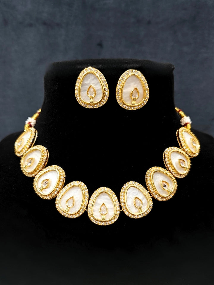 Close-up of an ornate traditional (Gold Polish) Mint Pink Collar Jewellery Set and Earrings with Mint Pink  Colored Stone and American Diamonds. Festive celebration look enhanced with sparkling artificial American Diamond jewelry. Saree look completed with elegant artificial American Diamond jewelry for festive occasions.