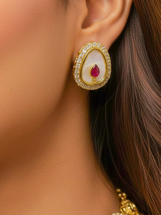 Close-up of a woman wearing an ornate traditional (Gold Polish) Red Collar Jewellery Set and Earrings with Red Colored Stone and American Diamonds. Festive celebration look enhanced with sparkling artificial American Diamond jewelry. Saree look completed with elegant artificial American Diamond jewelry for festive occasions.