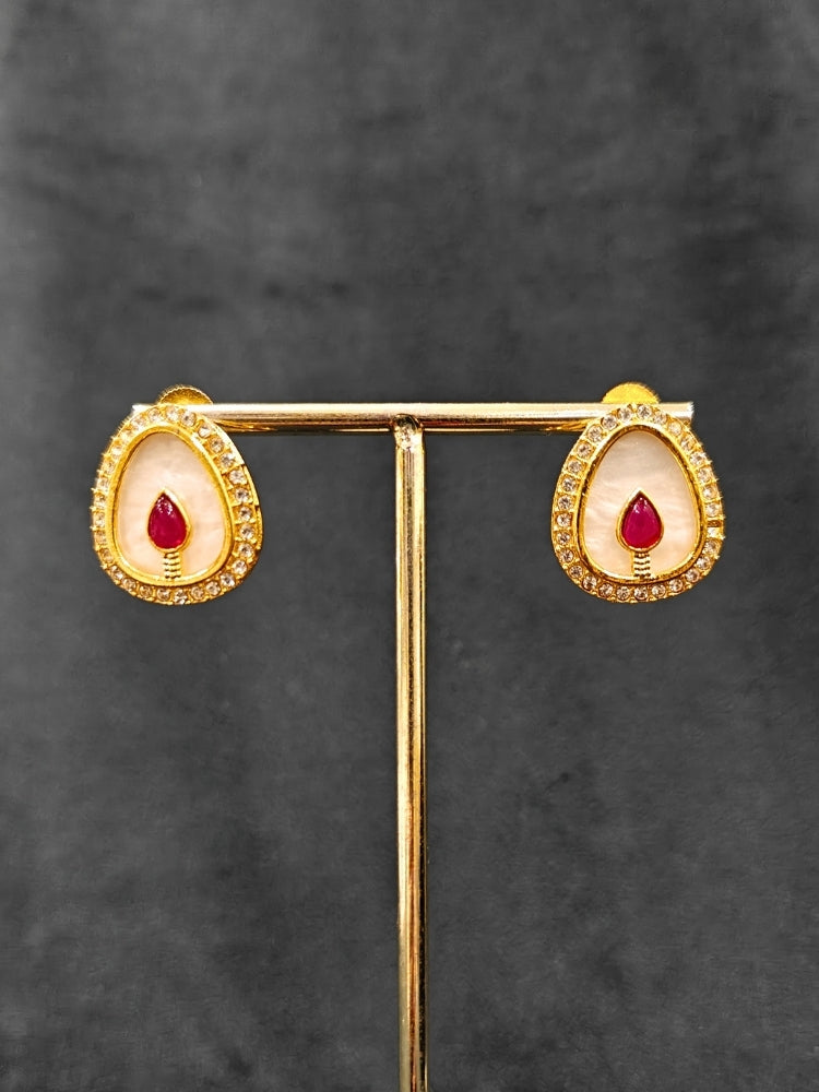 Close-up of an ornate traditional (Gold Polish) Red Collar Jewellery Set and Earrings with Red Colored Stone and American Diamonds. Festive celebration look enhanced with sparkling artificial American Diamond jewelry. Saree look completed with elegant artificial American Diamond jewelry for festive occasions.