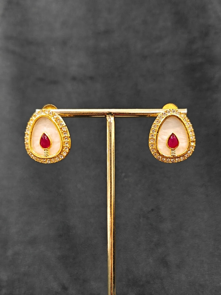 Close-up of an ornate traditional (Gold Polish) Red Collar Jewellery Set and Earrings with Red Colored Stone and American Diamonds. Festive celebration look enhanced with sparkling artificial American Diamond jewelry. Saree look completed with elegant artificial American Diamond jewelry for festive occasions.