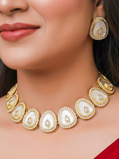 Close-up of a woman wearing an ornate traditional (Gold Polish) White Collar Jewellery Set and Earrings with American Diamond and American Diamonds. Festive celebration look enhanced with sparkling artificial American Diamond jewelry. Saree look completed with elegant artificial American Diamond jewelry for festive occasions.
