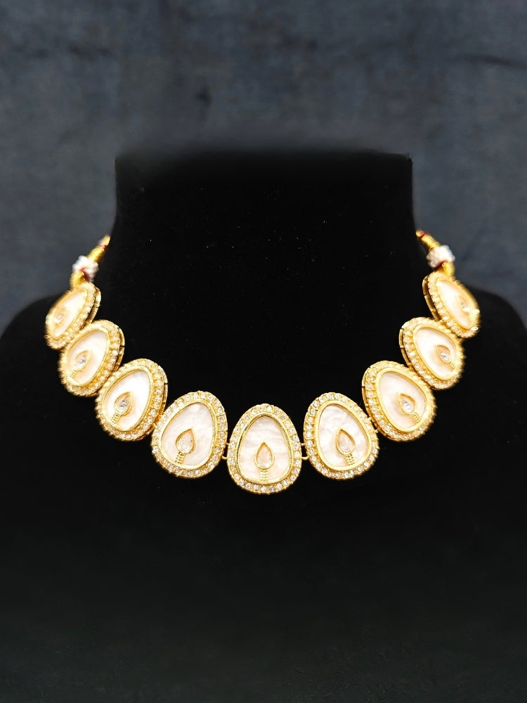 Close-up of an ornate traditional (Gold Polish) White Collar Jewellery Set and Earrings with American Diamond and American Diamonds. Festive celebration look enhanced with sparkling artificial American Diamond jewelry. Saree look completed with elegant artificial American Diamond jewelry for festive occasions.