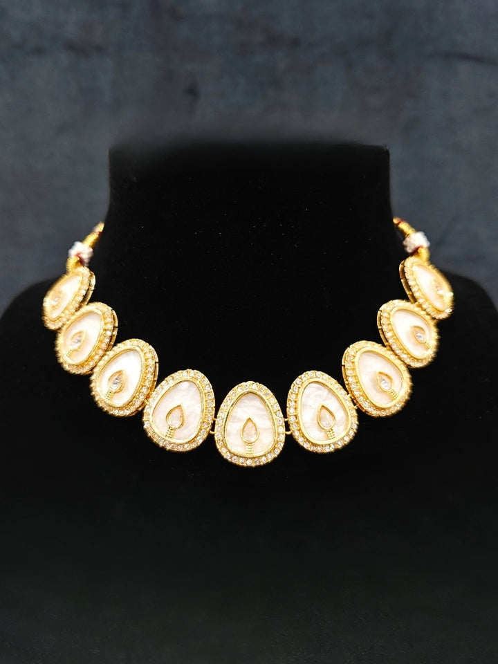 Close-up of an ornate traditional (Gold Polish) White Collar Jewellery Set and Earrings with American Diamond and American Diamonds. Festive celebration look enhanced with sparkling artificial American Diamond jewelry. Saree look completed with elegant artificial American Diamond jewelry for festive occasions.