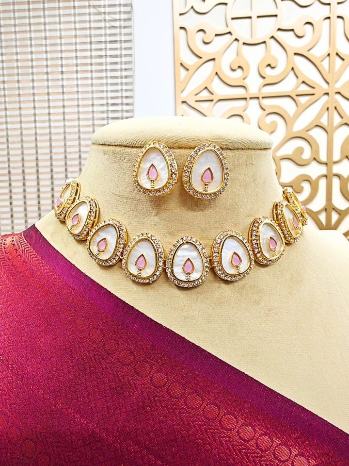 The Pragati Mint Pink Necklace Set features white necklace and matching earrings with white oval stones, surrounded by american diamonds, and teardrop-shaped multicolored gems in the center of each oval—perfect Wedding Ceremony Jewelry, shown on a mannequin bust.