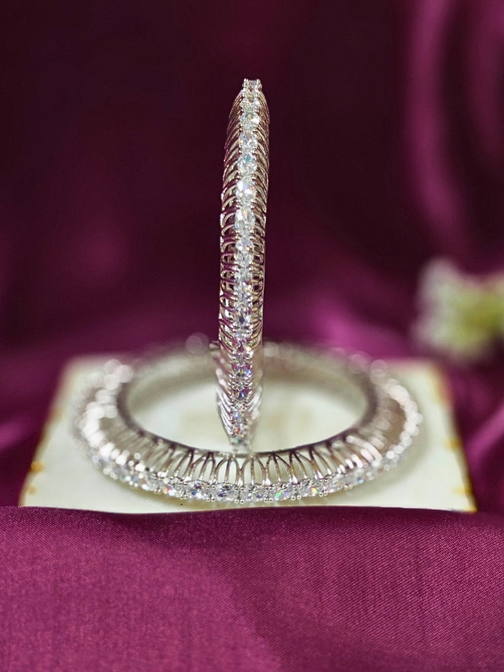 Close-up of an ornate Indo-western Silver Bangles with American Diamond. Wedding guest styling elegant artificial American Diamond bangles in India. Close-up of sparkling artificial American Diamond bangles for party wear. Luxury artificial American Diamond bangles styled for a wedding function.