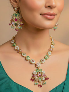 Close-up of a woman wearing an ornate traditional Collar Ruby Pink & Green jadau gold jewellery set and jadau earrings with beads and Color Stone. Elegant  look featuring a luxury Jadau artificial jewelry set. Woman wearing a royal Jadau necklace for festive events in India.
