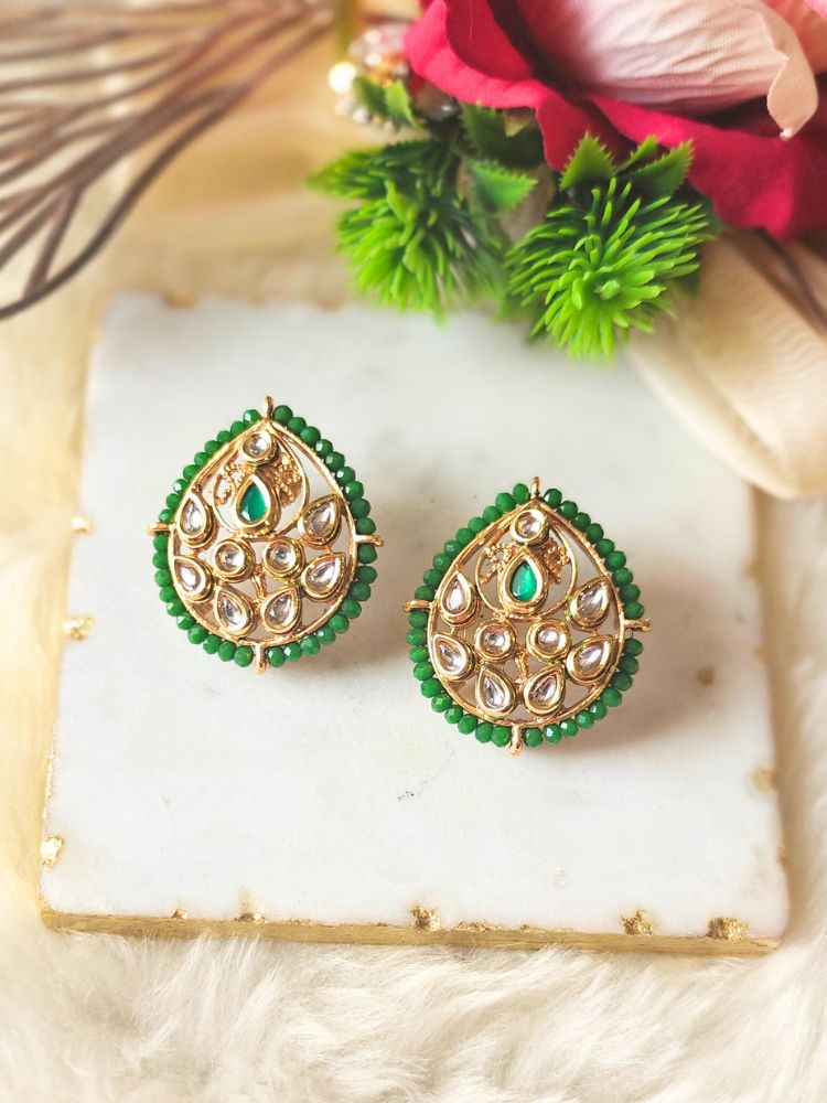 The Pranjal Green Earrings feature an ornate teardrop-shaped gold kundan design with white stones, green beads, and a central green gem—perfect for adding a touch of tradition to any look. Kundan Earrings from the Kundan collection. 