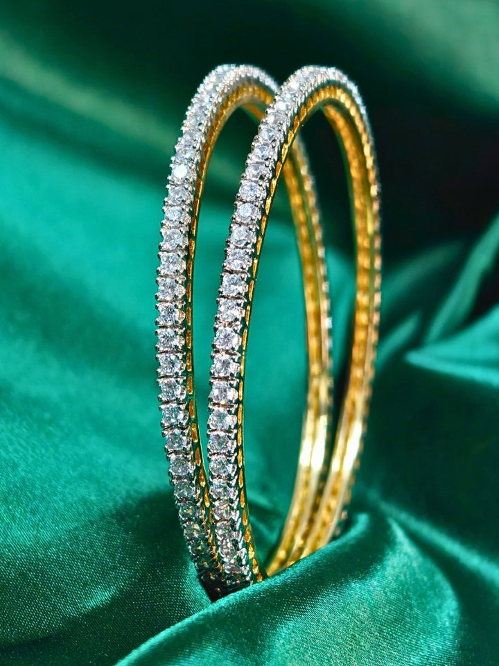 Close-up of an ornate Inod-Western (gold Polish) American Diamond Bangles Set. Elegant festive look with a high-quality imitation American diamond Bangles Set. Festive Diwali outfit styled with an American diamond artificial Bangles Set.