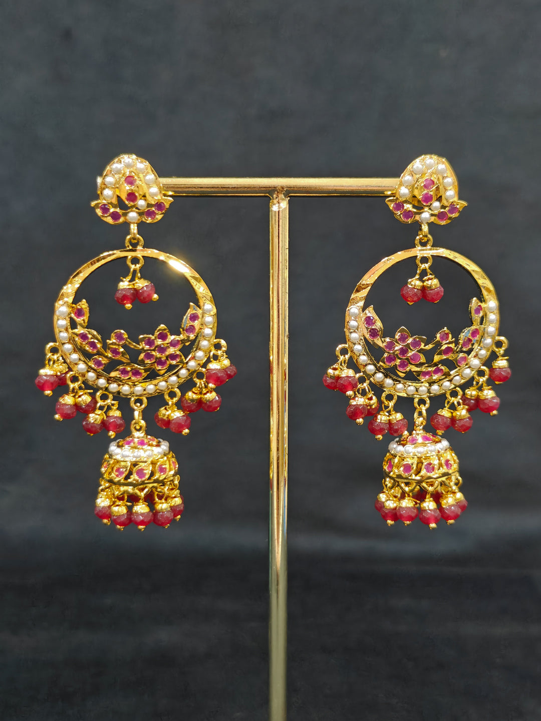 Close-up of a gold Indian traditional jadau jewellery with crystals beads and ruby pink jadau stones. This authentic jadau jewelry set can we worn as jadau necklace set for weddings. Festive celebration look featuring a Jadau artificial necklace.