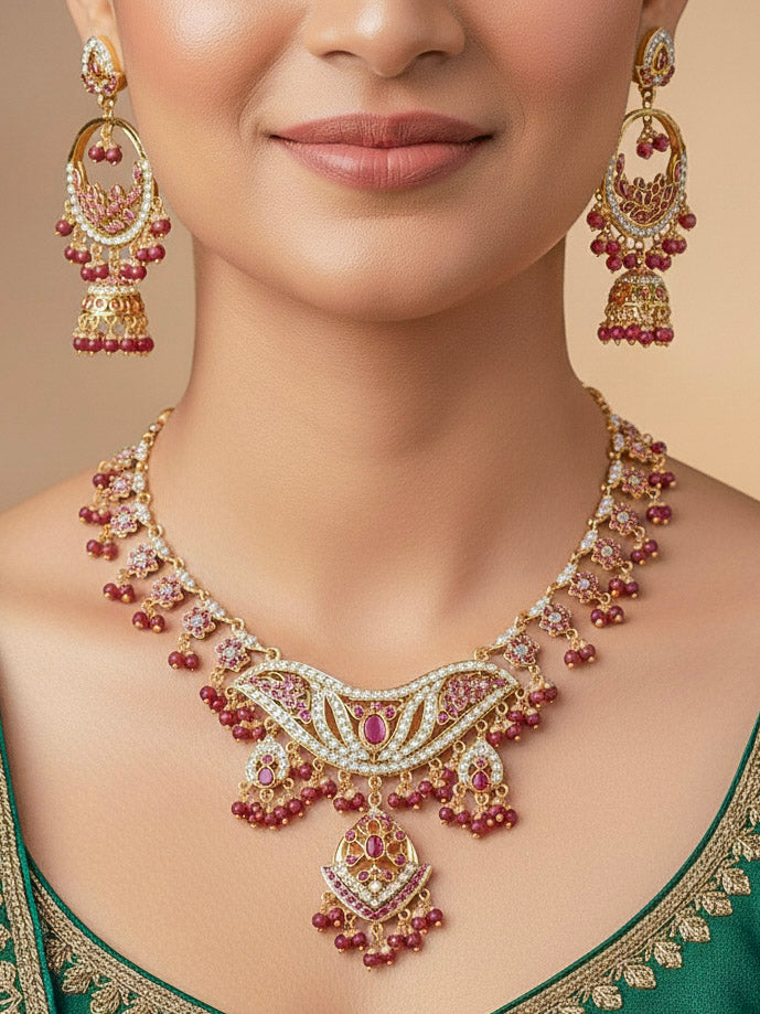 Close-up of a woman wearing a gold Indian traditional jadau jewellery with crystals beads and ruby pink jadau stones, and matching jadau earrings. This authentic jadau jewelry set can we worn as jadau necklace set for weddings. 