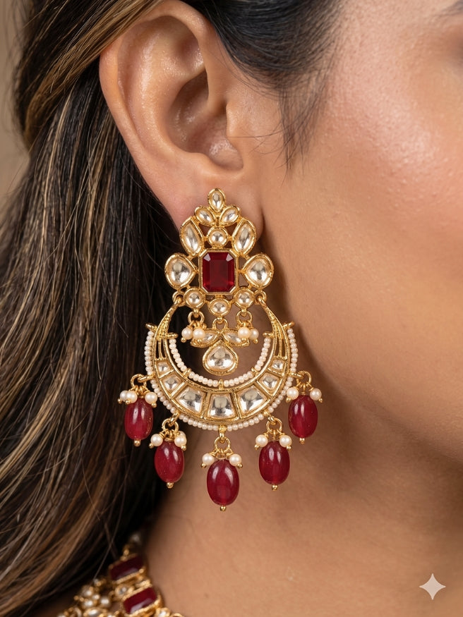 Close-up of a women wearing an ornate traditional (Gold Polish) Collar jewellery set and earrings and maangtikka with Red Colored Stones, Polki, Kundan, Tumble beads and Pearls. Bride wearing a statement Polki jewelry set for wedding photos. Woman wearing trending Polki artificial jewelry for the wedding season in India.