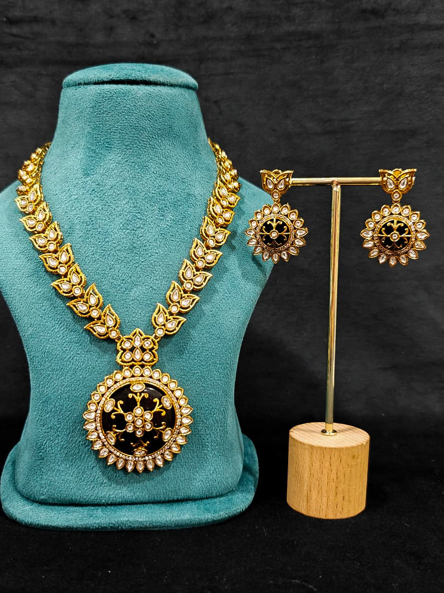 Close-up of an ornate traditional Black Rajwadi gold jewellery set and earrings with Black Colored Stones, Kundan, American Diamond. Close-up of a premium Rajwadi artificial necklace under 10000. Mehendi ceremony look styled with a Rajwadi artificial jewelry set.