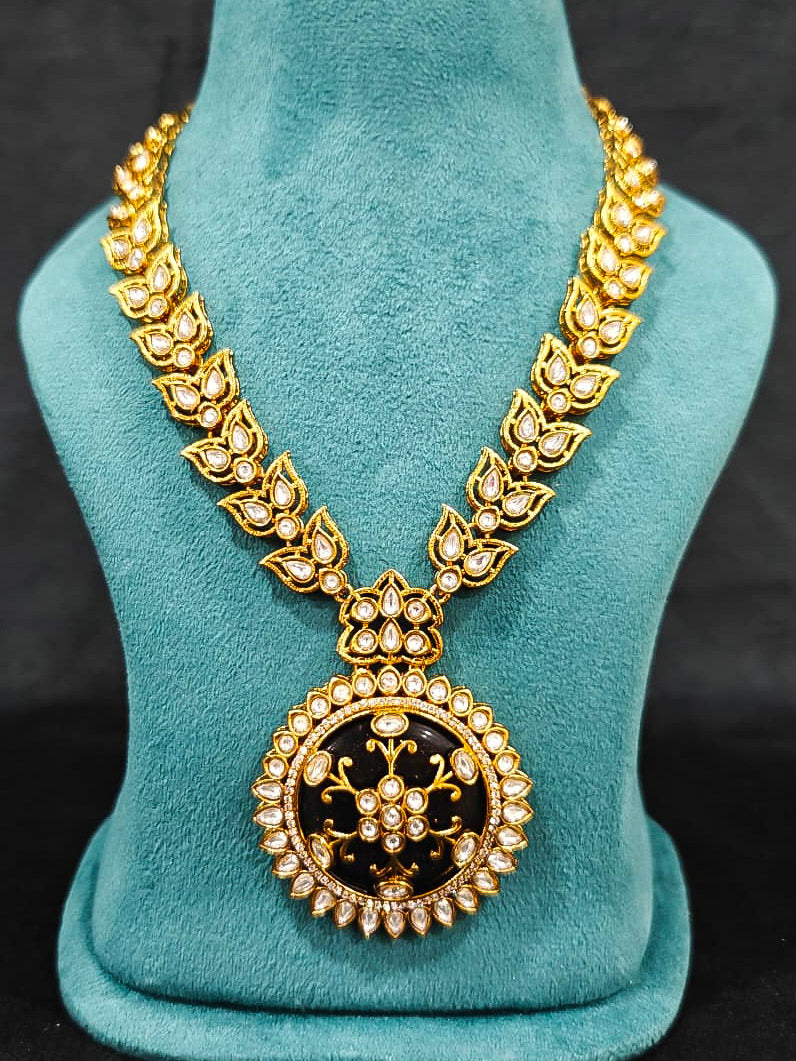 Close-up of an ornate traditional Black Rajwadi gold jewellery set and earrings with Black Colored Stones, Kundan, American Diamond. Close-up of a premium Rajwadi artificial necklace under 10000. Mehendi ceremony look styled with a Rajwadi artificial jewelry set.