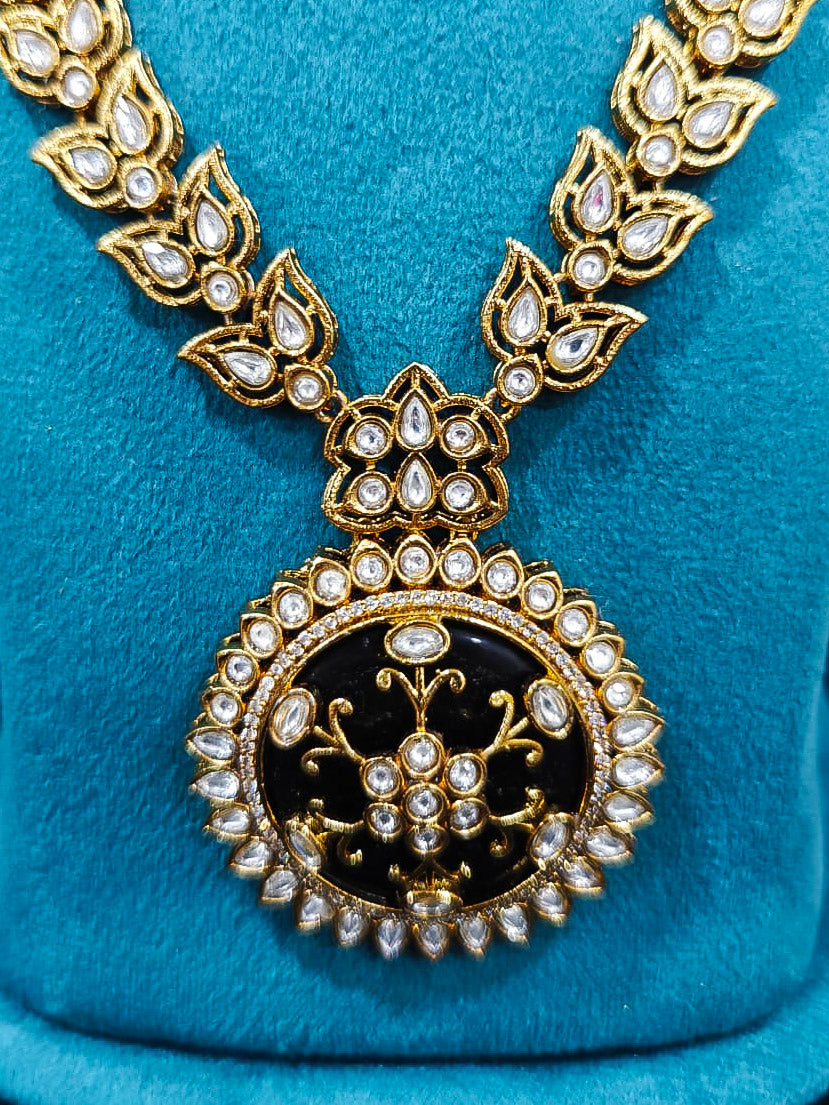 Close-up of an ornate traditional Black Rajwadi gold jewellery set and earrings with Black Colored Stones, Kundan, American Diamond. Close-up of a premium Rajwadi artificial necklace under 10000. Mehendi ceremony look styled with a Rajwadi artificial jewelry set.