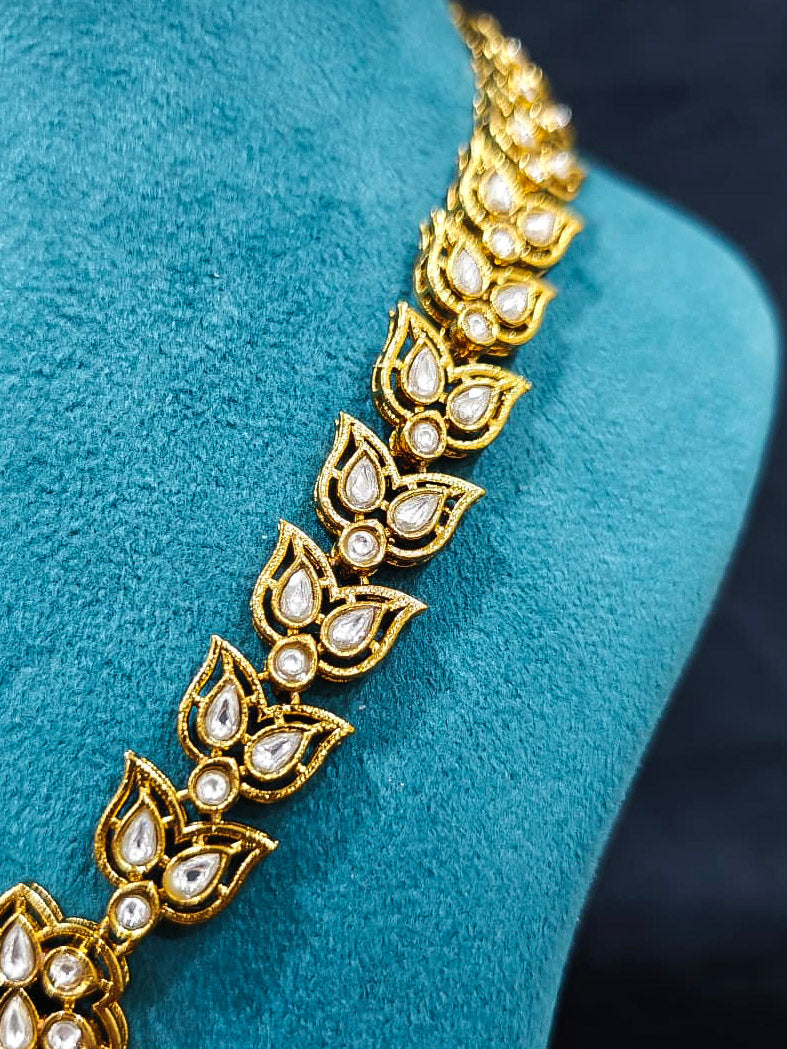 Close-up of an ornate traditional Black Rajwadi gold jewellery set and earrings with Black Colored Stones, Kundan, American Diamond. Close-up of a premium Rajwadi artificial necklace under 10000. Mehendi ceremony look styled with a Rajwadi artificial jewelry set.