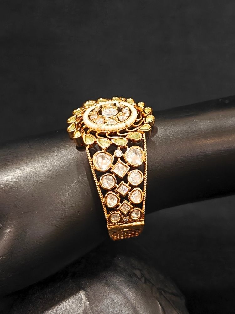 Close-up of an ornate traditional (Gold Polish) Mint Green Bracelet with Polki, Mint Green Colored Stones and Pearl. Close-up of an anti-tarnish artificial Polki bracelet styled for wedding guests.Festive outfit paired with a premium imitation Polki bracelet in India.