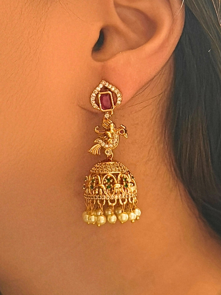Close-up of a woman wearing an ornate traditional (gold Polish) Diamond Earrings with American Diamond, Colored Stones and Pearls. Wedding guest wearing a sparkling American diamond Earrings with a saree. Festive Diwali outfit styled with an American diamond artificial Earrings.