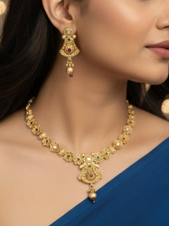 Close-up of a woman wearing an ornate traditional (Gold Polish) Collar jewellery set and earrings with Colored Stones. Mehendi ceremony look completed with a handcrafted Colored Stone jewelry set. Woman wearing trending Colored Stone artificial jewelry for wedding season in India.