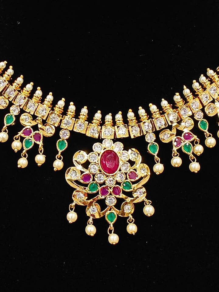 Close-up of an ornate traditional (Gold Polish) Collar jewellery set and earrings with pearls, ruby &amp; Emerald Colored Stone and American Diamond. Festive Diwali outfit styled with an American diamond artificial necklace. Close-up shot of a high-quality American diamond artificial necklace worn for festive celebrations.
