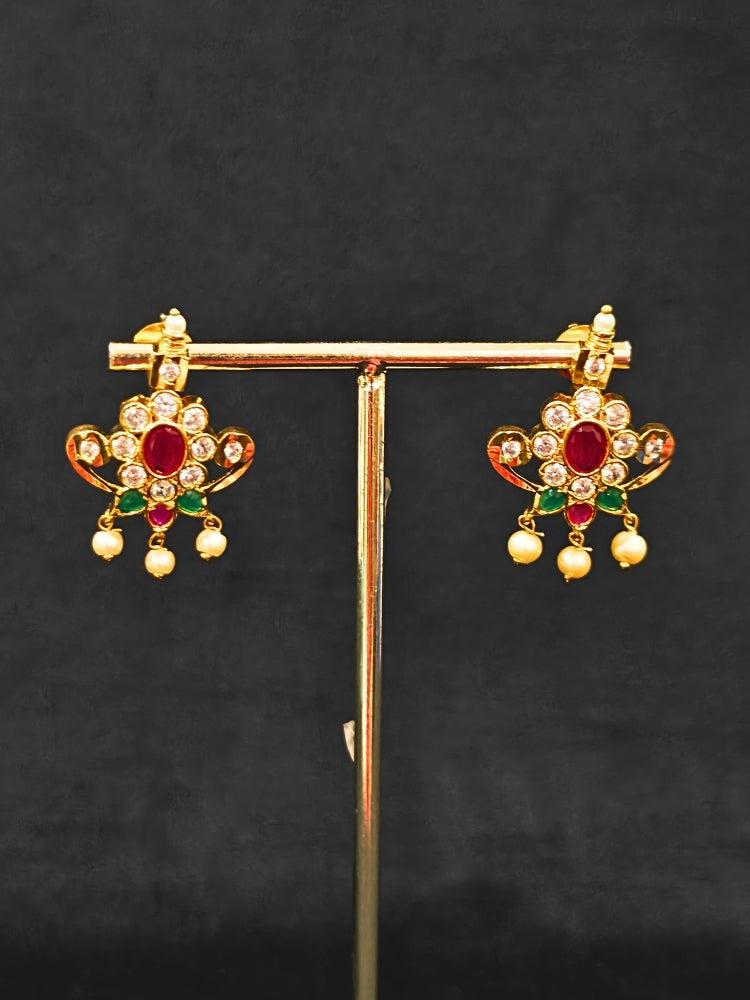 Close-up of an ornate traditional (Gold Polish) Collar jewellery set and earrings with pearls, ruby &amp; Emerald Colored Stone and American Diamond. Festive Diwali outfit styled with an American diamond artificial necklace. Close-up shot of a high-quality American diamond artificial necklace worn for festive celebrations.