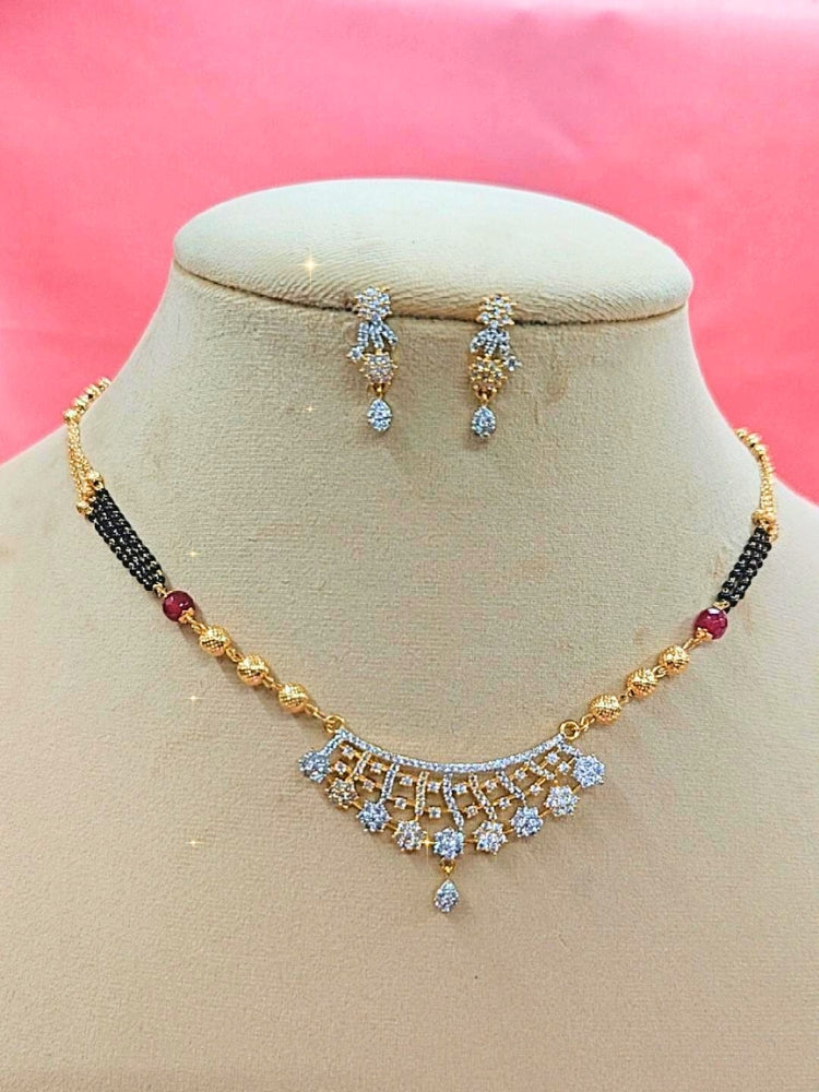 Priyanshi Mangalsutra—a gold necklace with black mangalsutra beads and matching earrings, pendant featuring sparkling American Diamonds—set against a cream dummy, perfect for your wedding ceremony dress. Diamond mangalsutra. Modern mangalsutra. 