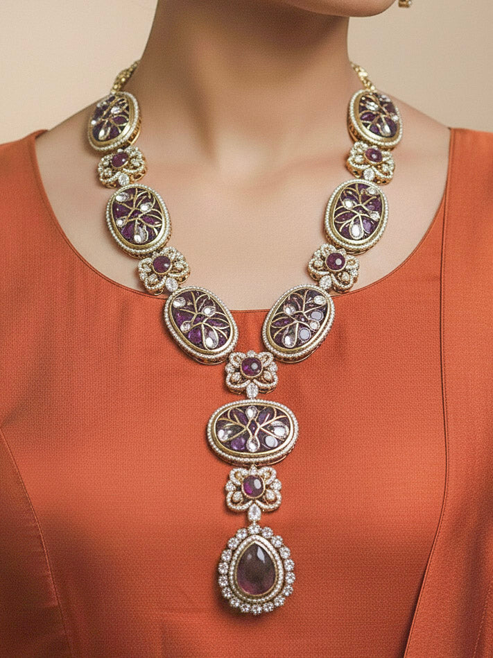 Close-up of a woman wearing an ornate traditional (Mehendi Gold Antique Finish) Purple long Colored Stone jewellery set and earrings with Kundan, Monalisa Stone and American Diamonds. Close-up of a premium imitation Colored Stones jewelry set styled with a aanarkali. Woman wearing trending Colored Stones artificial jewelry for wedding season in India.