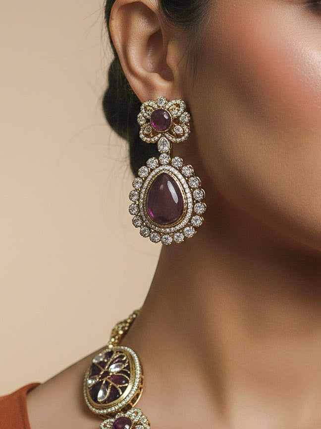 Close-up of a woman wearing an ornate traditional (Mehendi Gold Antique Finish) Purple long Colored Stone jewellery set and earrings with Kundan, Monalisa Stone and American Diamonds. Close-up of a premium imitation Colored Stones jewelry set styled with a aanarkali. Woman wearing trending Colored Stones artificial jewelry for wedding season in India.