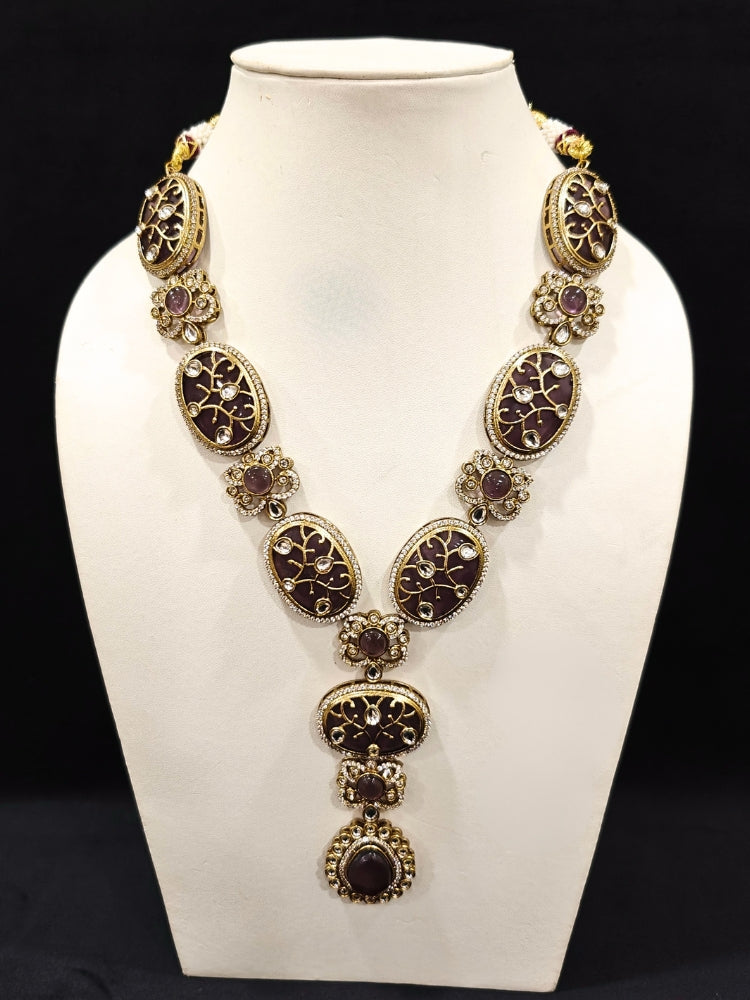 Close-up of an ornate traditional (Mehendi Gold Antique Finish) Purple long Colored Stone jewellery set and earrings with Kundan, Monalisa Stone and American Diamonds. Close-up of a premium imitation Colored Stones jewelry set styled with a aanarkali. A trending Colored Stones artificial jewelry for wedding season in India.
