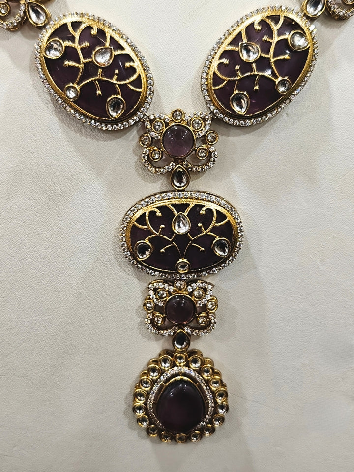 Close-up of an ornate traditional (Mehendi Gold Antique Finish) Purple long Colored Stone jewellery set and earrings with Kundan, Monalisa Stone and American Diamonds. Close-up of a premium imitation Colored Stones jewelry set styled with a aanarkali. A trending Colored Stones artificial jewelry for wedding season in India.