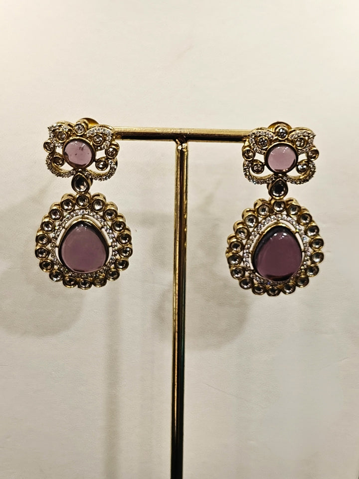 Close-up of an ornate traditional (Mehendi Gold Antique Finish) Purple long Colored Stone jewellery set and earrings with Kundan, Monalisa Stone and American Diamonds. Close-up of a premium imitation Colored Stones jewelry set styled with a aanarkali. A trending Colored Stones artificial jewelry for wedding season in India.