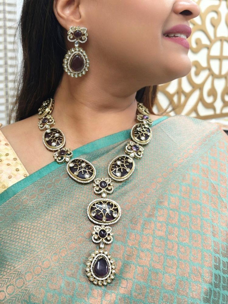 A woman showcasing a beautiful artificial diamond necklace with purple colored stone and earrings set, ideal for festivals, family gatherings, and special celebrations in India. This high-end artificial diamond jewelry set combines style, elegance, and affordability for special occasions.