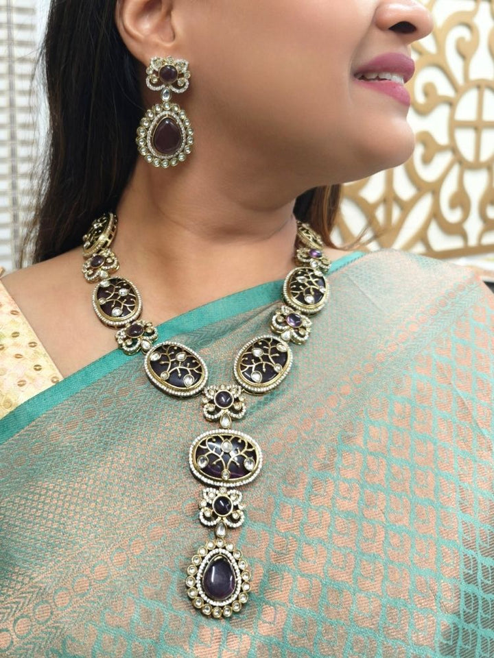 A woman showcasing a beautiful artificial diamond necklace with purple colored stone and earrings set, ideal for festivals, family gatherings, and special celebrations in India. This high-end artificial diamond jewelry set combines style, elegance, and affordability for special occasions.
