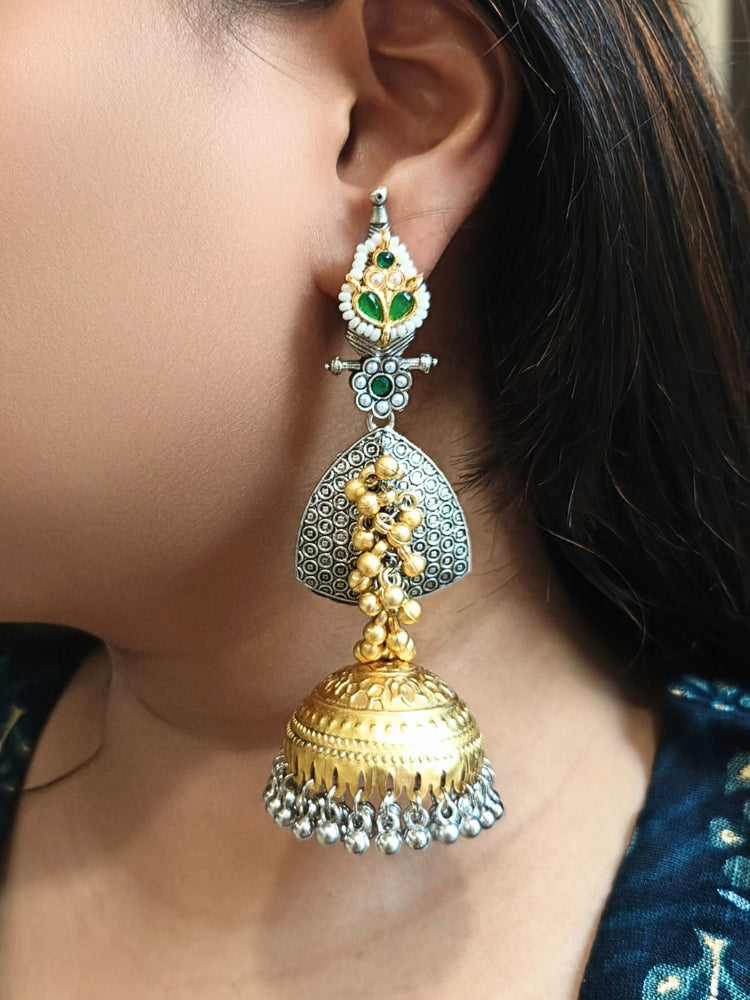 Close-up of a woman wearing Raagmani Green Earrings, featuring silver, gold, and Green details with kundan work and dangling ghungroos —a stunning choice to pair with your wedding ceremony dress. Oxidized earrings, german silver earrings, navratri earrings. 