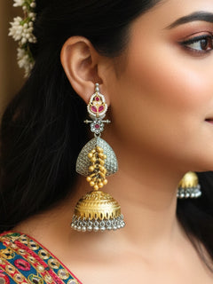 Close-up of a women wearing an ornate traditional (Gold and Silver Polish) Red Long Earrings set with Green Colored Stone. Close-up of anti-tarnish artificial Oxidized earrings for festive celebrations. Festive saree look completed with premium imitation Oxidized earrings.