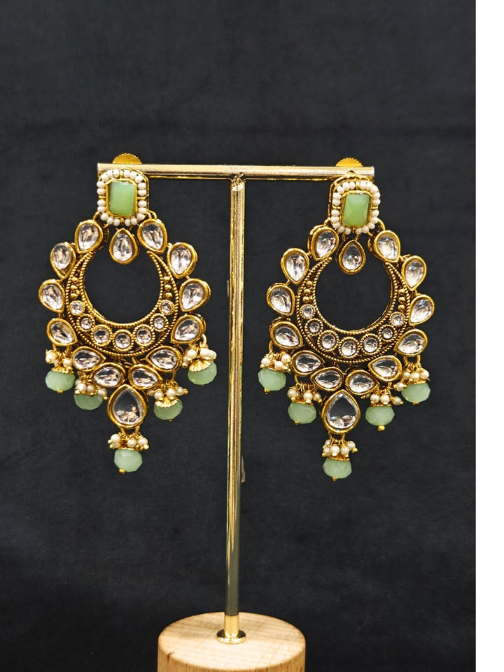 Close-up of an ornate traditional Green Kundan Choker jewellery set and earrings and maangtikka with Kundan, Mint green Stone, Pearls and Mint Green Crystal Beads. Bride wearing a royal Kundan artificial necklace for wedding rituals. Wedding celebration look enhanced with a statement Kundan necklace. 