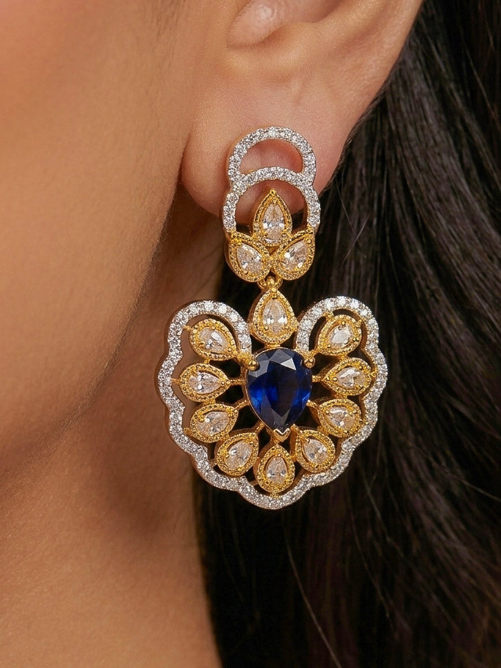 Close-up of a woman wearing an ornate Western American diamond Raizel Blue Necklace Set (Dual Tone) Collar jewellery set and earrings with Colored Stone and American Diamond. Bride-to-be styled in a premium American diamond artificial necklace for her reception party.