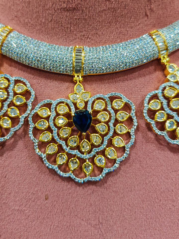 Close-up of an ornate Western American diamond Raizel Blue Necklace Set (Dual Tone) Collar jewellery set and earrings with Colored Stone and American Diamond. Close-up of a cocktail party look featuring a premium American diamond necklace.