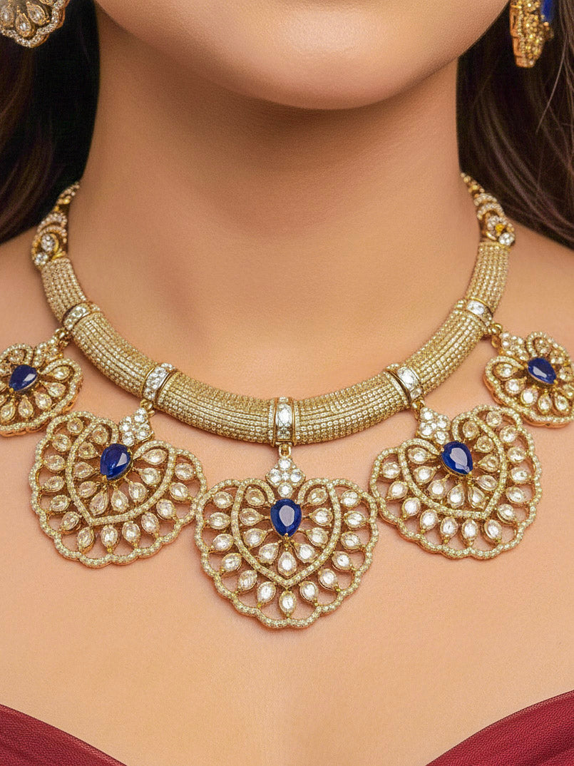 Close-up of a woman wearing an ornate Western American diamond Raizel Blue Necklace Set (Mehendi Polish) Collar jewellery set and earrings with Colored Stone and American Diamond. Reception-ready look featuring a statement American diamond jewelry set.
